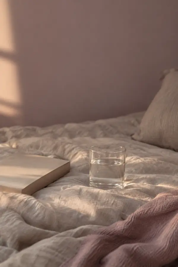 Water, linen and a closed book in soft evening light